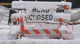 Snow covered road closed sign
